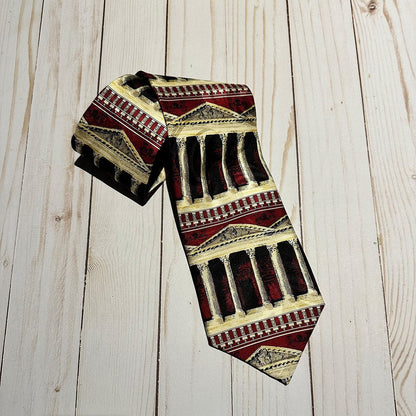 Greek architecture columns tie in maroon, cream and black on a wooden surface