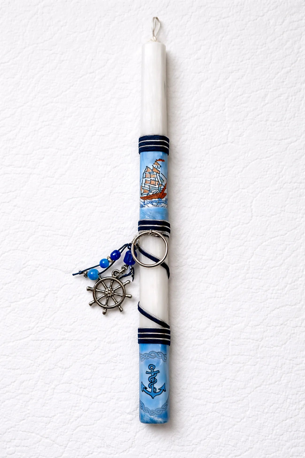 Decorative candle with nautical design on a white background