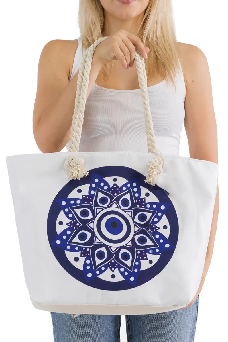 Woman holding a white tote bag with a blue evil eye mandala design
