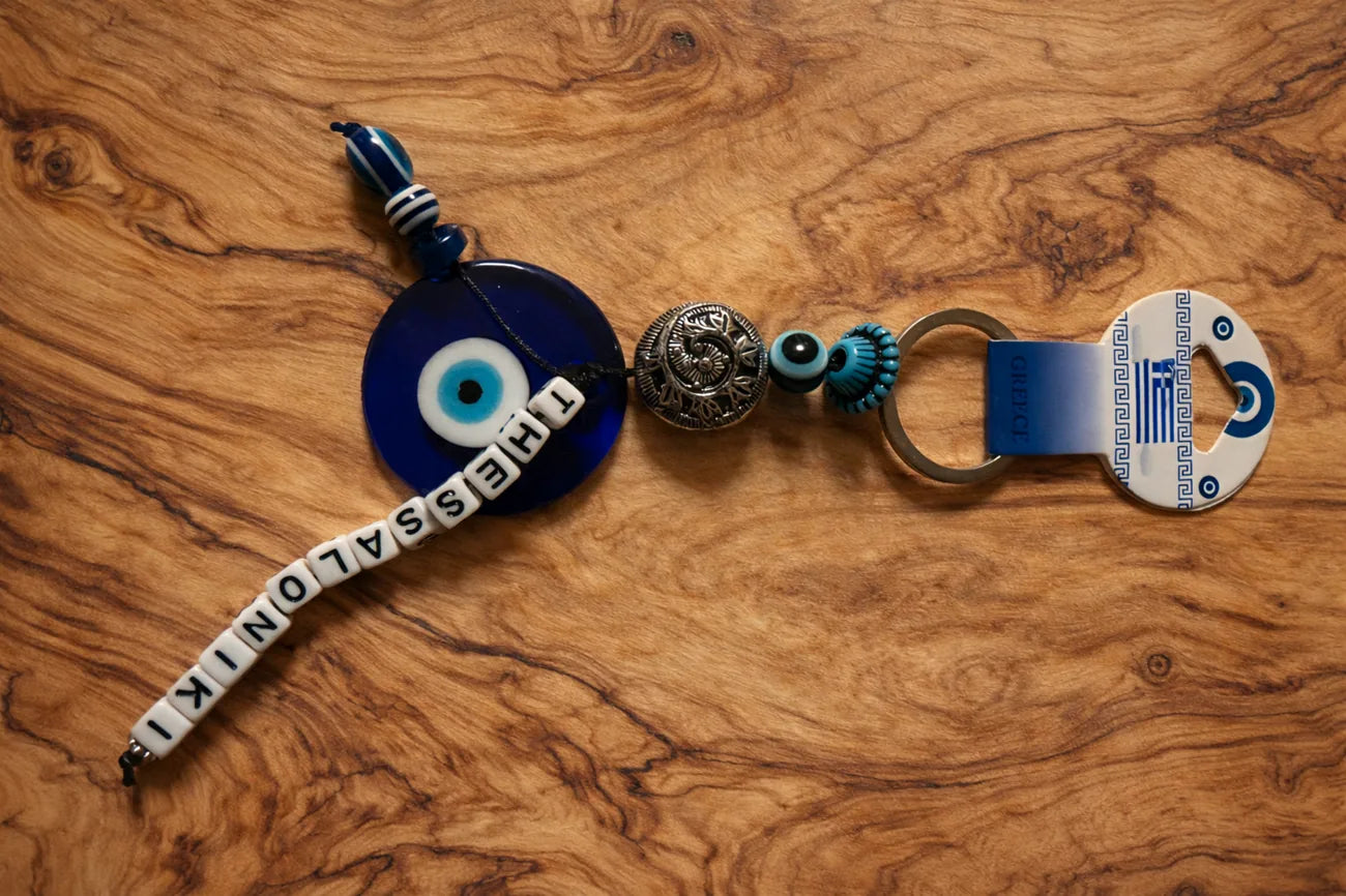 Keychain with Greek Evil Eye and Thessaloniki design on a wooden surface