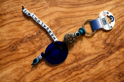 Keychain with beads and a blue pendant on a wooden surface