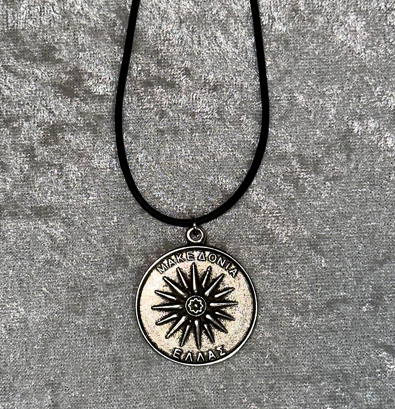 Necklace with a circular pendant featuring a star design on a textured gray background