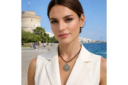 Woman wearing a necklace with a castle and sea in the background